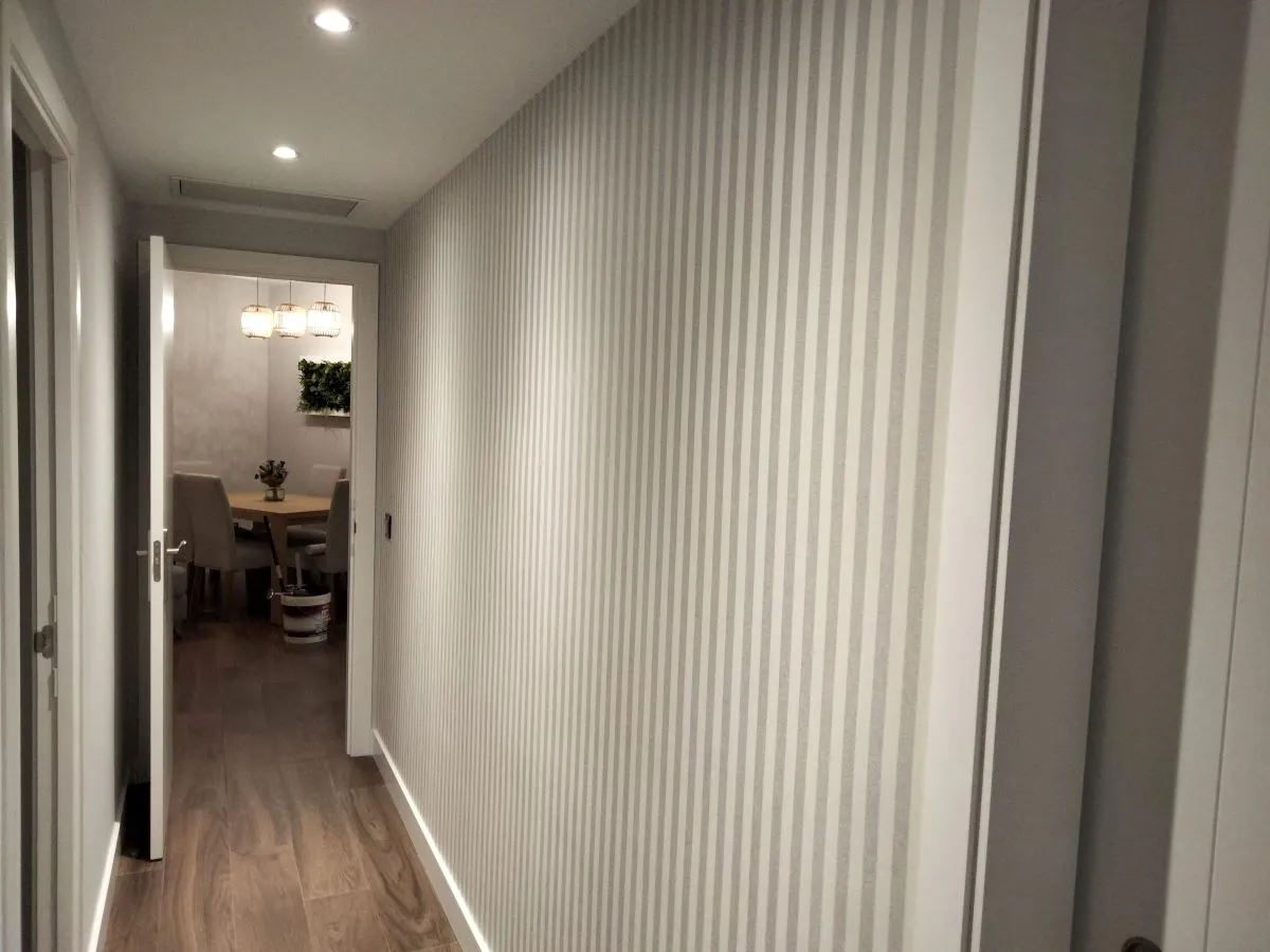 Empapelado de salón en vivienda de Sevilla con papel pintado decorativo.